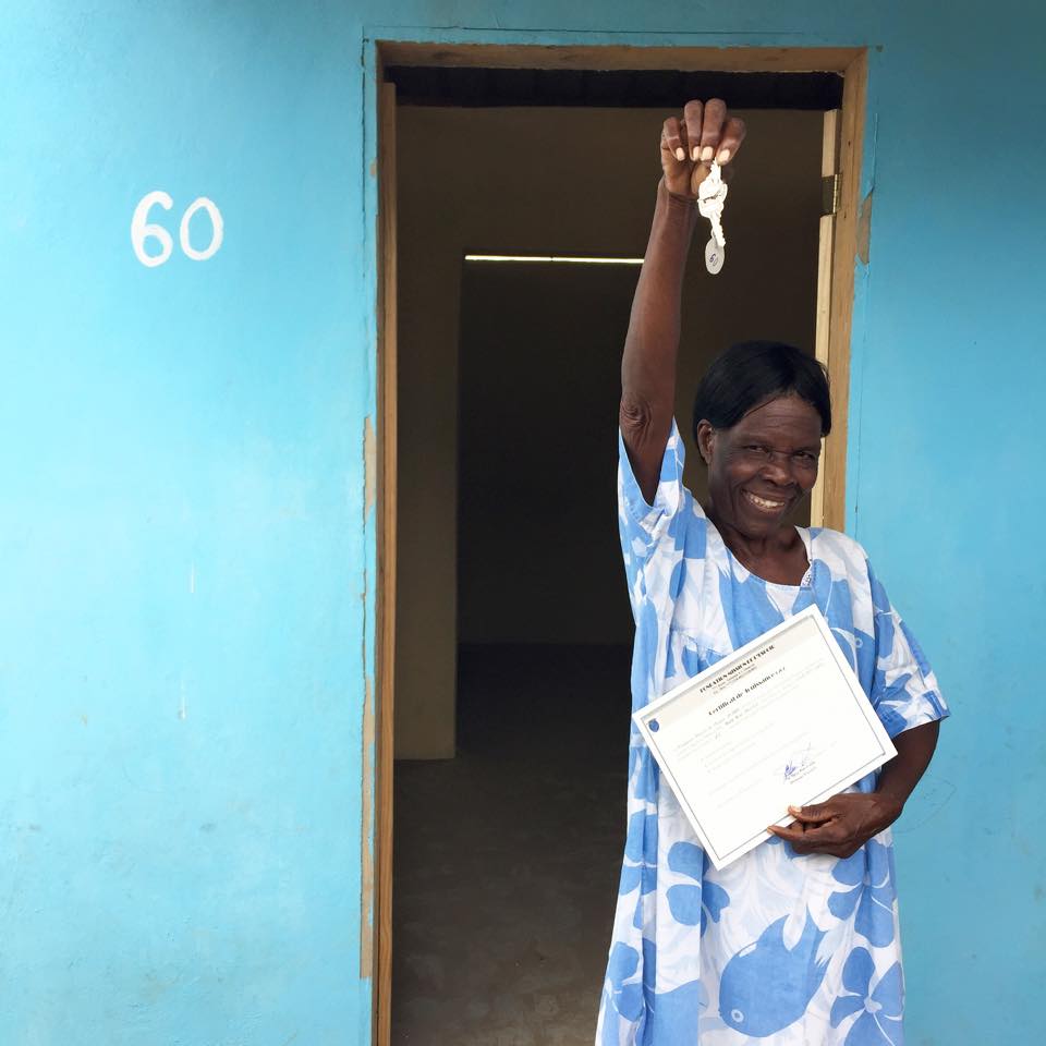Maria Rose, a widow with four children who lost her home in the earthquake that hit Haiti in 2010, stands happily outside her new home.