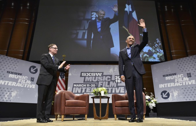 US President Barack Obama waves as he and Texas Tribune editor Evan Smith (L) arrive for a South by Southwest Interactive at the Long Center for Performing Arts in Austin, Texas on March 11, 2016. / AFP / MANDEL NGAN