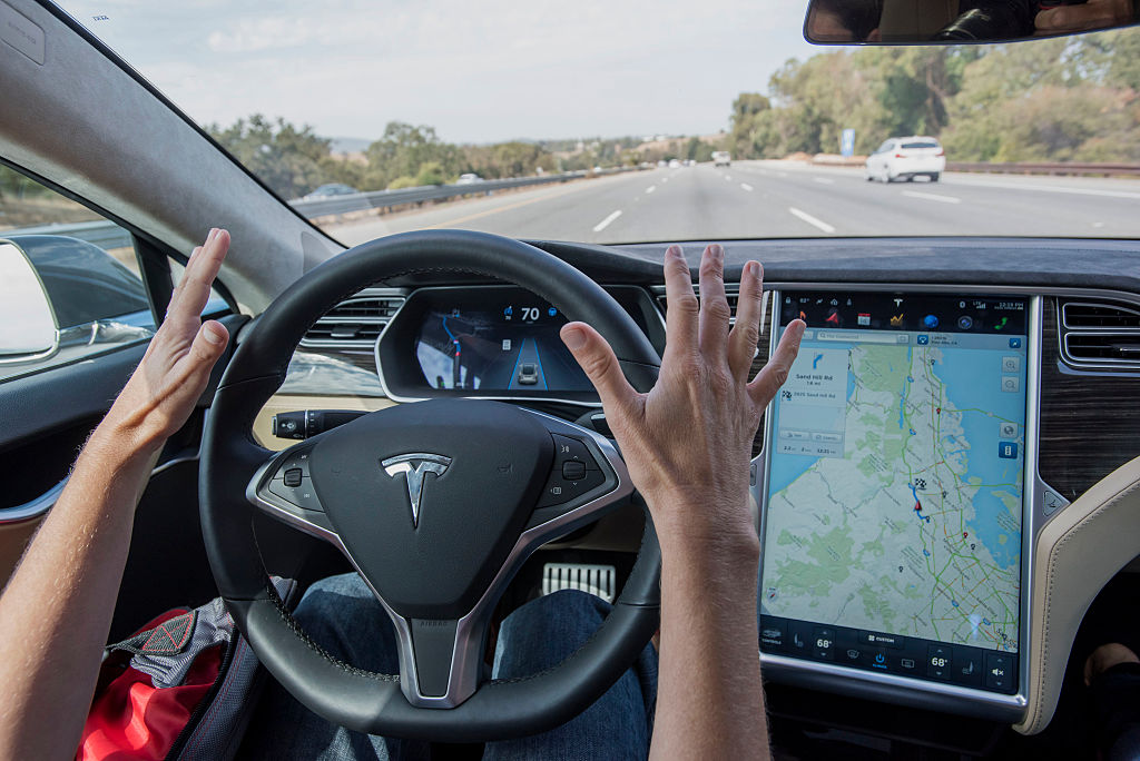 A member of the media test drives a Tesla Motors Inc. Model S car equipped with Autopilot in Palo Alto, California, U.S., on Wednesday, Oct. 14, 2015. Tesla Motors Inc. will begin rolling out the first version of its highly anticipated "autopilot" features to owners of its all-electric Model S sedan Thursday. Autopilot is a step toward the vision of autonomous or self-driving cars, and includes features like automatic lane changing and the ability of the Model S to parallel park for you. Photographer: David Paul Morris/Bloomberg via Getty Images