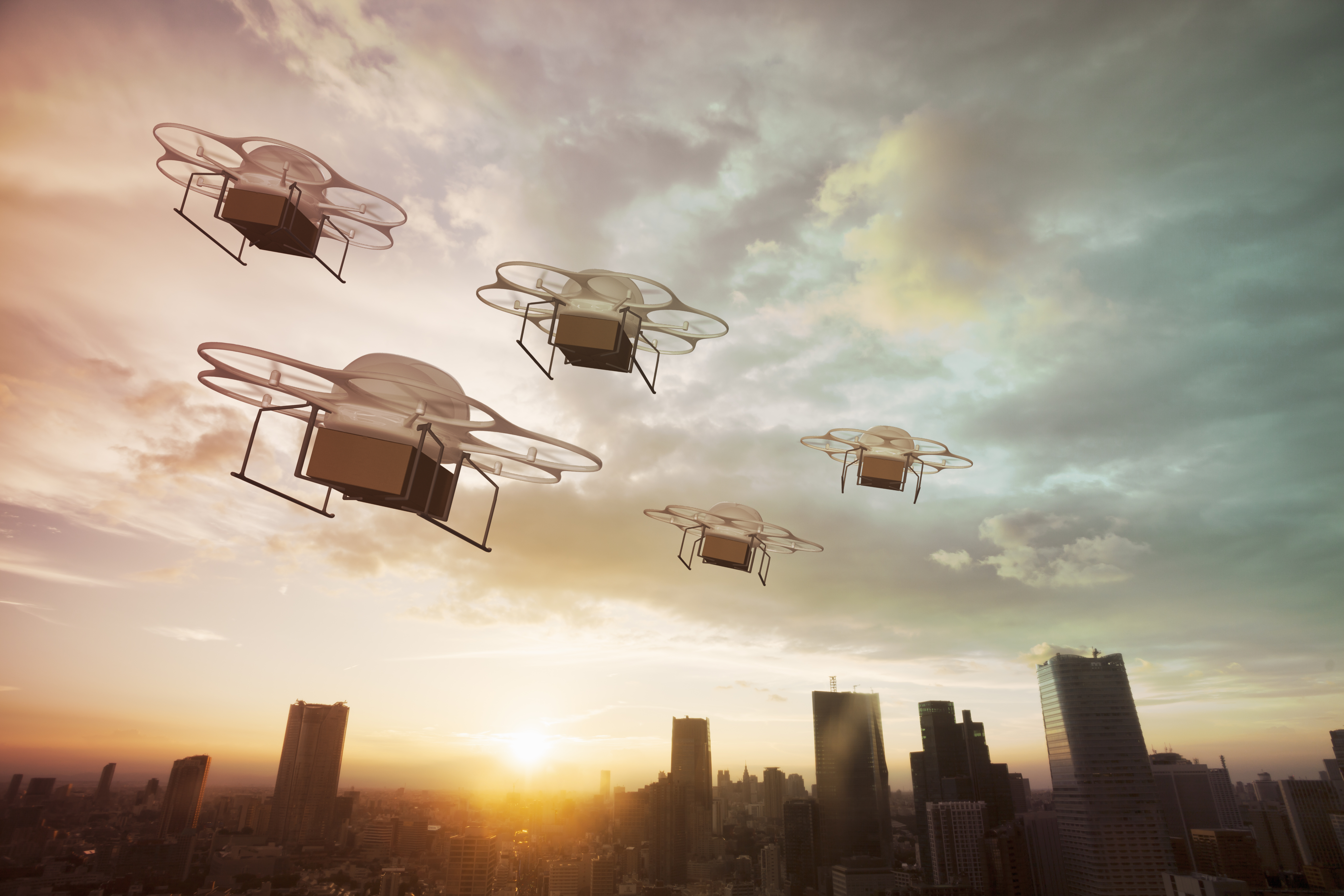 Five delivery drones flying above the city at sunset GettyImages 649629414